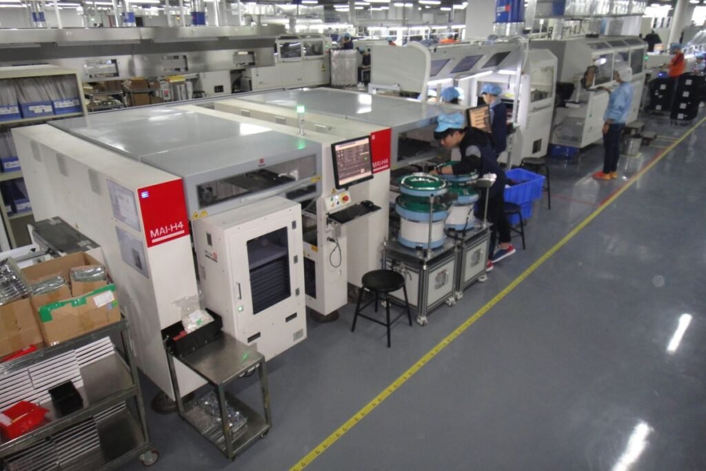 Voltronic Power factory workers operating advanced production equipment