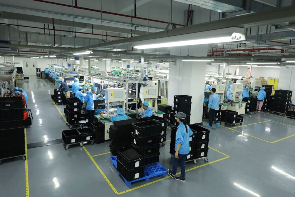 Voltronic Power factory workers operating advanced production equipment