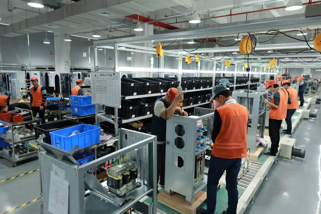 Voltronic Power factory workers operating advanced production equipment