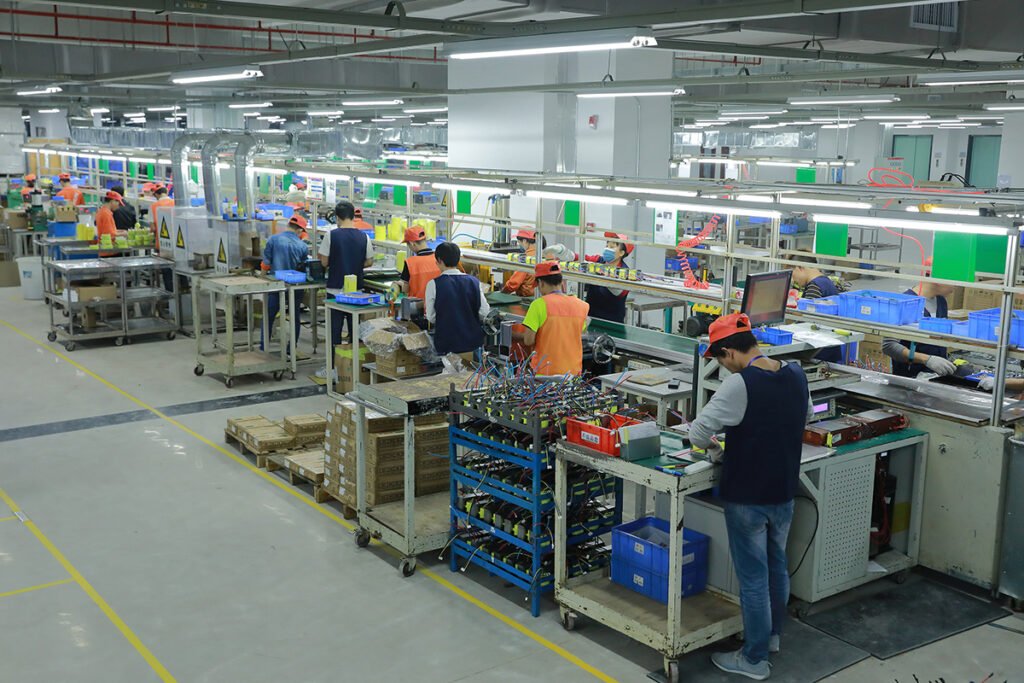 Voltronic Power factory workers operating advanced production equipment
