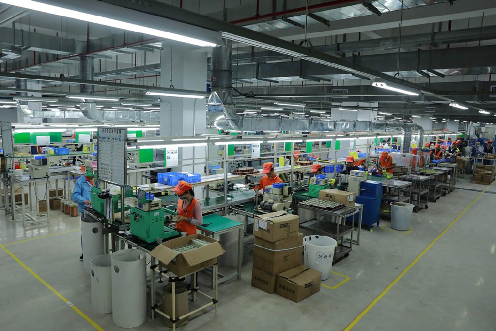 Voltronic Power factory workers operating advanced production equipment